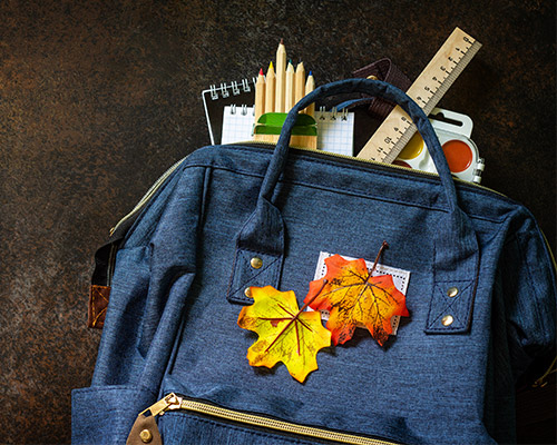 Sac rentrée scolaire et feuilles d'automne