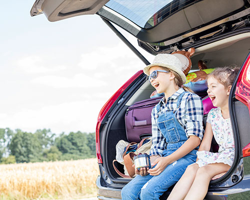 Enfants en voiture pour le départ en vacances